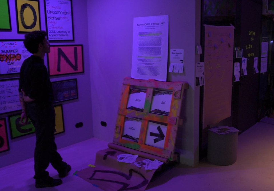 A visitor looking at the Slow Looking installation under purple light
